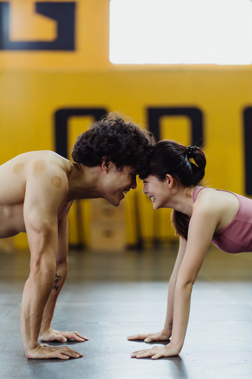 a couple smiling at each other with their hands on the floor